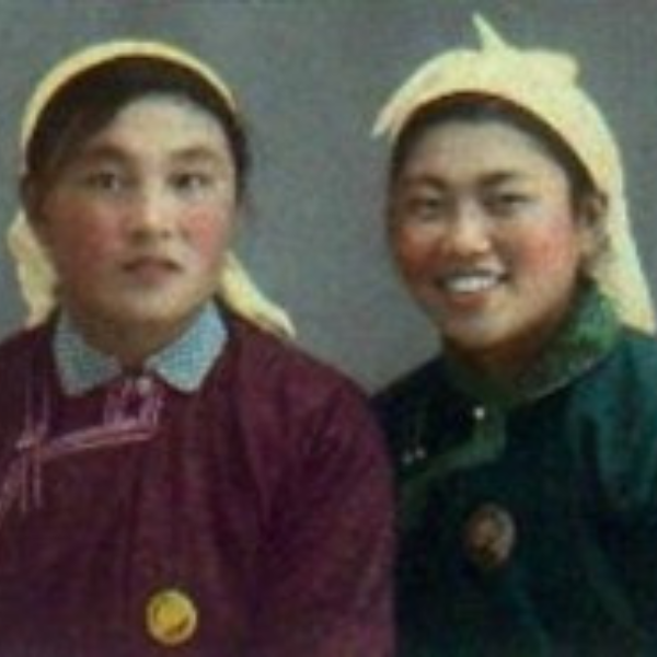 Photo of two young Asian ladies smiling and wearing headscarves and colourful clothes